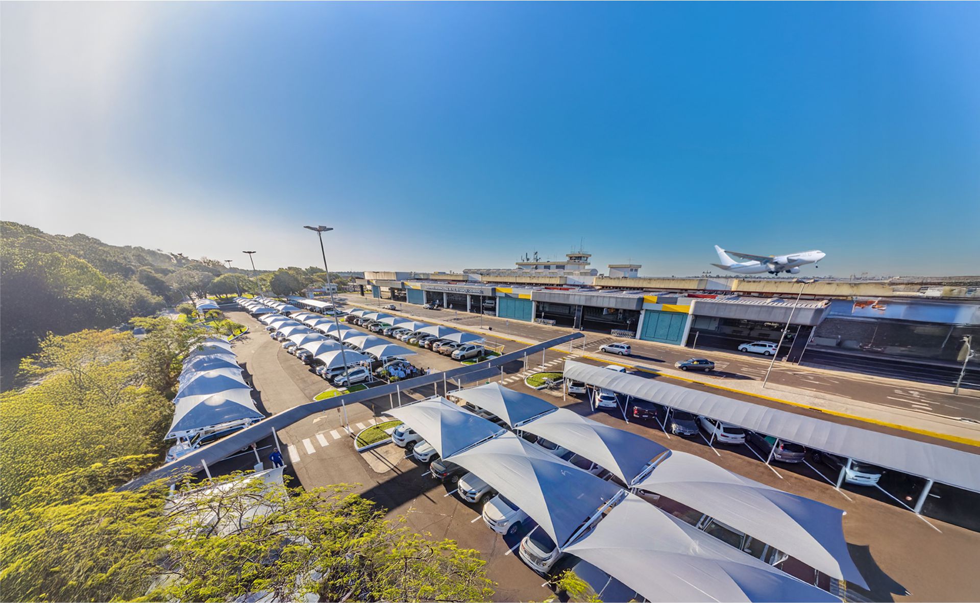 Estacionamento Tarobá - Aeroporto Internacional de Foz do Iguaçu Vista panorâmica do estacionamento Tarobá no Aeroporto de Foz do Iguaçu com veículos estacionados e segurança